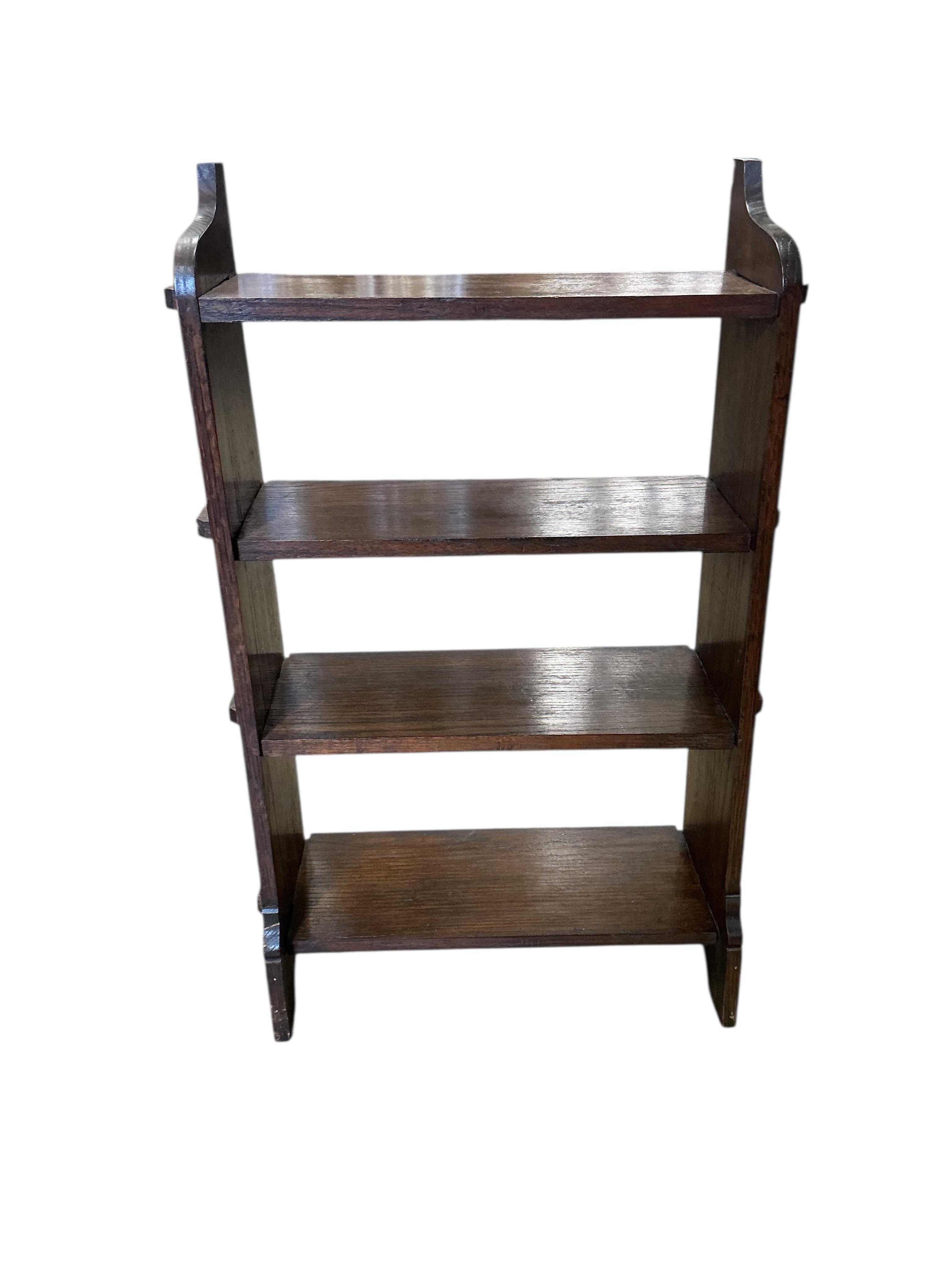 A small Arts & Crafts oak three tier open bookcase, width 60cm, depth 21cm, height 96cm